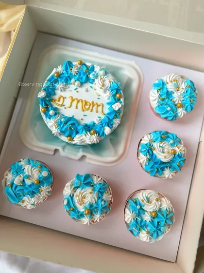 My bento cake and cupcake combo is perfect for gifting. This set was for a lovely mom, featuring a mini cake and five matching cupcakes, all decorated in a beautiful blue and white theme.
