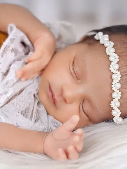 I love capturing those fleeting expressions, like this sweet, sleepy smile. This close-up portrait showcases the baby's delicate features and the soft texture of the faux fur she is resting on.