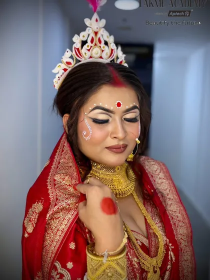 A beautiful and soft portrait of a Bengali bride. The makeup emphasizes a natural glow, with a focus on the eyes and the traditional bindi and chandan art.