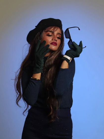 A creative studio portrait focusing on the interaction between the subject and her sunglasses, creating a sense of mystery and style.