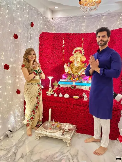 A lovely client couple offering their prayers. The bold red floral wall provides a powerful and passionate backdrop for their devotion during Ganesh Chaturthi.