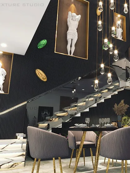 For this Meera Bagh residence, the client wanted a dramatic fusion of luxury and edgy design. I created this double-height dining area featuring a staircase with a glass railing, black louvered walls, and recessed niches for modern sculptures, all illuminated by striking pendant lights.