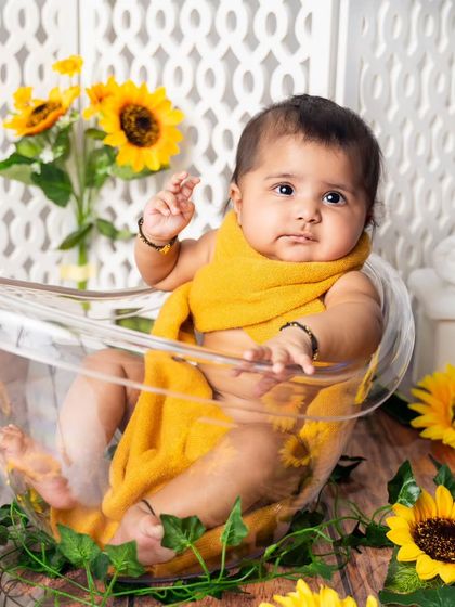 Bath time in a field of sunflowers. This fun shot is part of a six-month milestone session, adding a playful and unique element to the gallery.