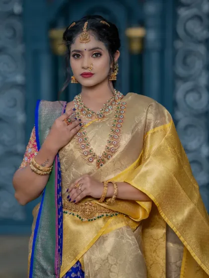 A close-up of the makeup, showing a soft glam look that complements the gold and blue outfit.