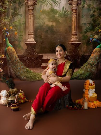 A grand portrait of a mother and child in a setting inspired by royal gardens, complete with majestic peacocks. This showcases one of my more elaborate Janmashtami backdrops.