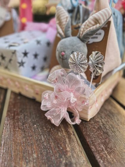 Another detail shot, focusing on a plush bunny and delicate paper pinwheels that add a touch of handmade whimsy to the grand welcome gift.