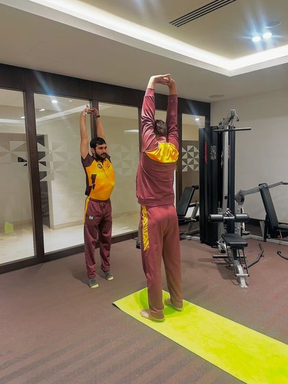 A full-body overhead stretch helps lengthen the spine and open the shoulders, which is critical for cricketers, especially bowlers and batsmen. I guide athletes through each movement to maximize its benefit.