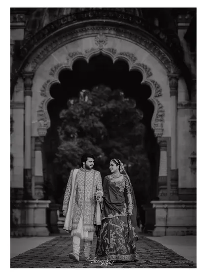 The grandeur of the palace and the elegance of the couple are amplified in this stunning black and white architectural portrait.