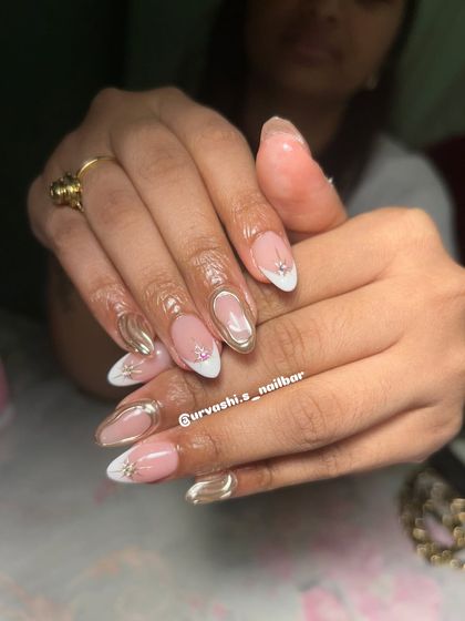 This festive design combines a classic white French tip with modern gold chrome swirls and tiny star-shaped rhinestone accents. It's a glamorous and sophisticated look.