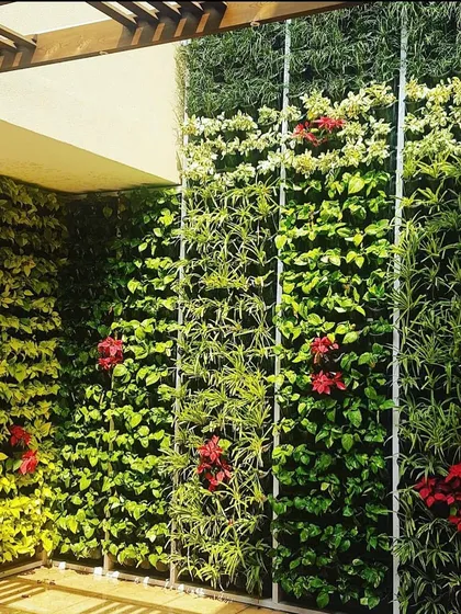A balcony doesn't have to be a boring, empty space. Here is a full vertical garden wall I installed for a client, turning their outdoor area into a private green sanctuary with a mix of leafy plants and colorful flowers.