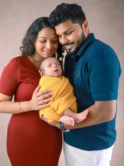 Wrapped in love, held forever in their arms. This portrait shows the feeling of protection and peace as parents cradle their sleeping newborn.