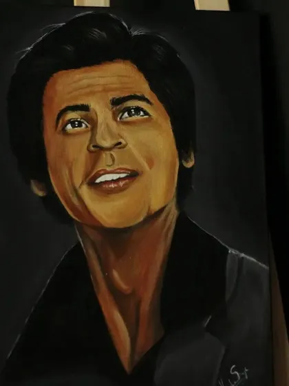 An angled view of the SRK painting, highlighting the lighting and shadows on his face.