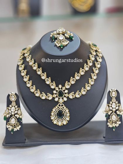 A beautiful double-layered AD necklace with a peacock motif and green stones.