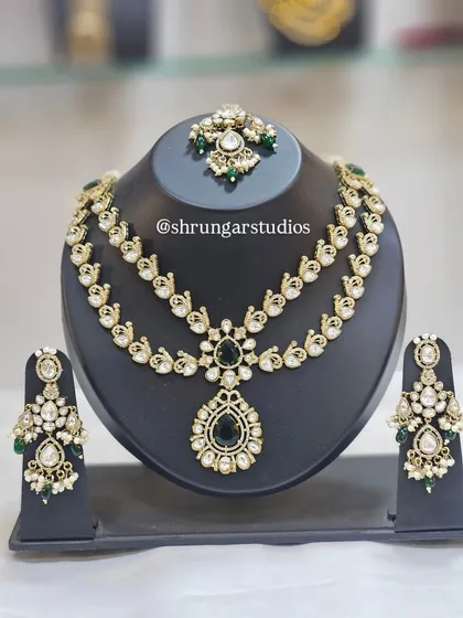 A beautiful double-layered AD necklace with a peacock motif and green stones.