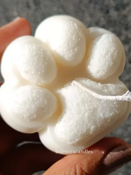 A close-up of the paw-shaped candle, showing its cute and detailed design.