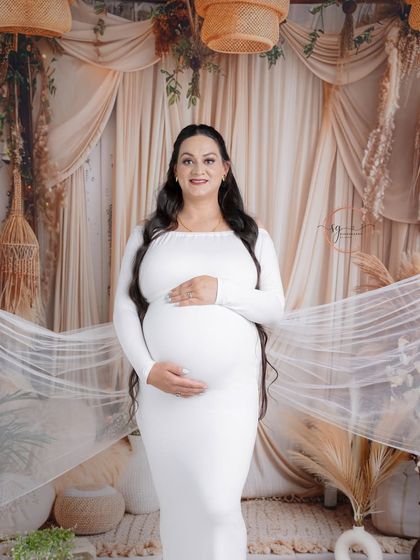 A classic full-length portrait in a fitted white gown. The boho-chic backdrop adds texture and warmth to this beautiful solo shot.