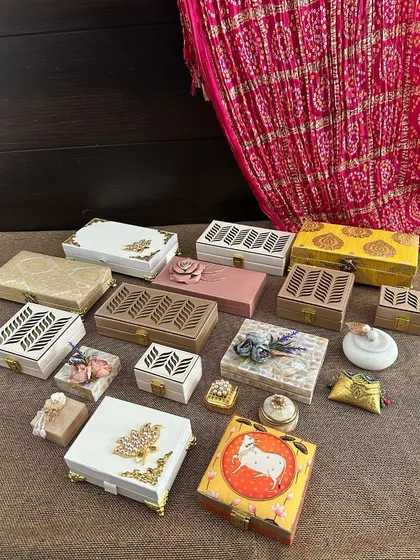 Here is the ultimate inspiration for brides-to-be! This image is a flat lay of various trousseau essentials, from ornate boxes and coin pouches to decorative trays, to help you plan your wedding shopping.
