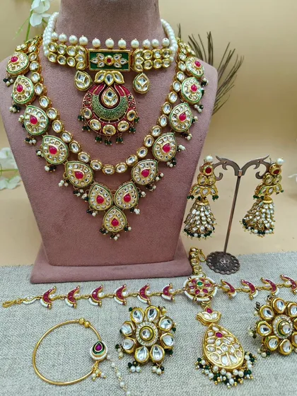 This is what a full bridal rental set looks like. It includes a choker, a long necklace (rani haar), earrings, a nath (nose ring), haath phool (hand harness), and a maang tikka. I ensure every piece is coordinated to give you a complete, polished look.