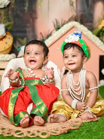 Double the fun! A photo of twin babies dressed as Krishna, sharing a happy moment.