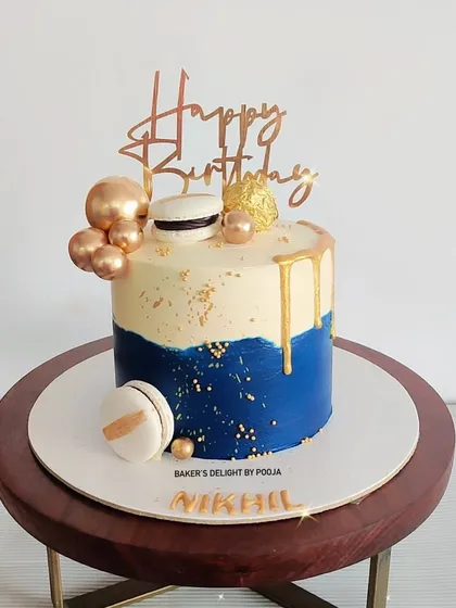 A classy and elegant cake in blue and white with gold drip and macaron accents, perfect for celebrating the men in your life.