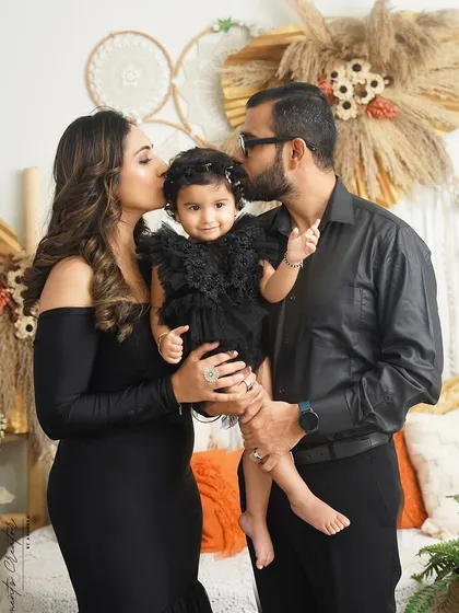 Sweet kisses for their one-year-old daughter. This photo is a testament to the love and adoration parents have for their child, captured in a single, beautiful moment.
