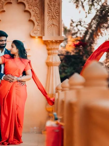 A dramatic pre-wedding portrait with the bride's red saree flowing in the wind. This technique adds movement and a touch of cinematic flair to the image.