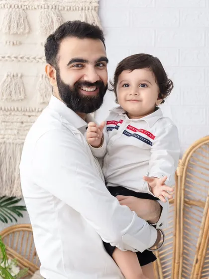 A heartwarming father and son portrait. The genuine smiles and comfortable setting make this a perfect capture of their bond.