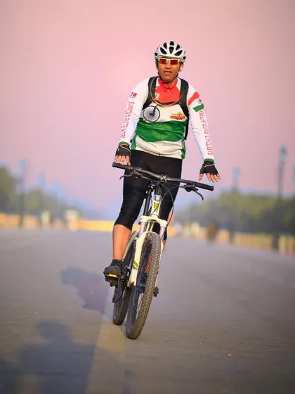 A cyclist doing a wheelie on an empty road. We have some skilled riders in our group who love to show off their tricks.