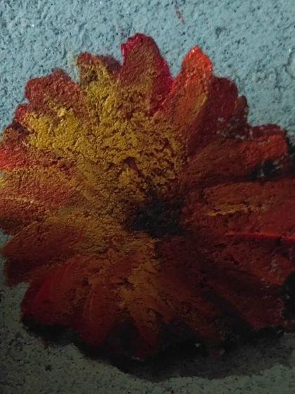 A macro shot of one of the painted marigold flowers from the home mural. The layered colors and brushwork create a sense of depth and texture, making the flowers appear to float on the wall.