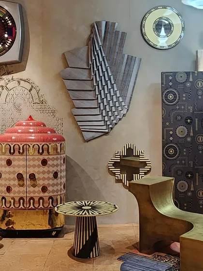 A collection of decor items from the 'Indofuturism' installation. The pieces blend traditional Indian motifs with futuristic shapes and finishes, creating a unique and surreal aesthetic.