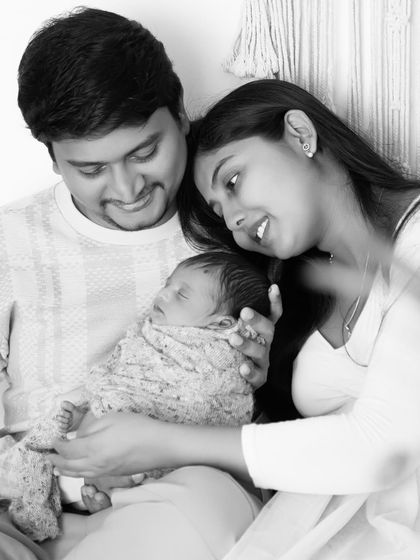 A candid black and white moment from a lifestyle session. The image feels authentic and warm, capturing the family relaxing together in the studio.