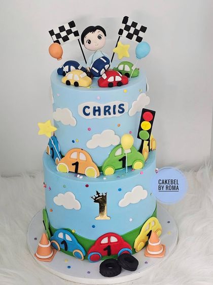 A full view of the two-tier car cake against a clean background.