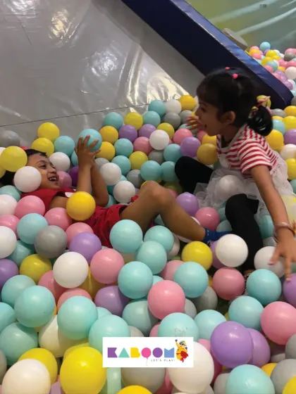 Sharing a laugh in the ball pit. It's a great place for siblings and friends to bond and create happy memories.