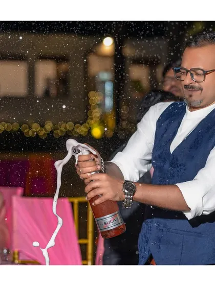 The celebration begins! A guest pops a bottle of champagne, a classic shot that signals the start of a great party.