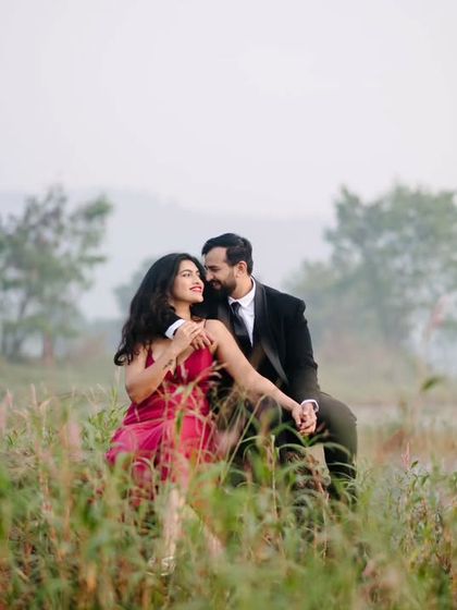 An intimate moment nestled in the tall grass by the lake. The natural elements frame the couple, making the scene feel private and romantic.