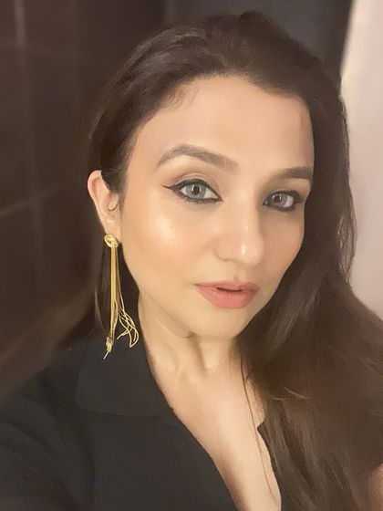 A different makeup look, featuring a sharp winged liner and a nude lip.