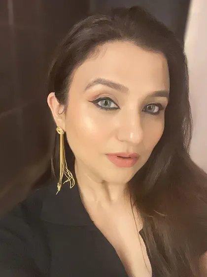 A different makeup look, featuring a sharp winged liner and a nude lip.