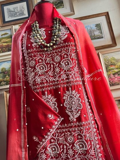 A full view of the Sindoori Red suit on a mannequin, showcasing its vibrant color and regal presence.