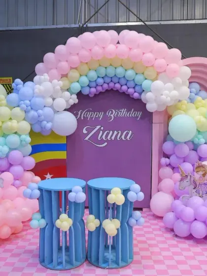 A beautiful unicorn and rainbow-themed birthday setup for Ziana. The pastel colors, cloud-like balloons, and unicorn figures create a truly enchanting atmosphere.