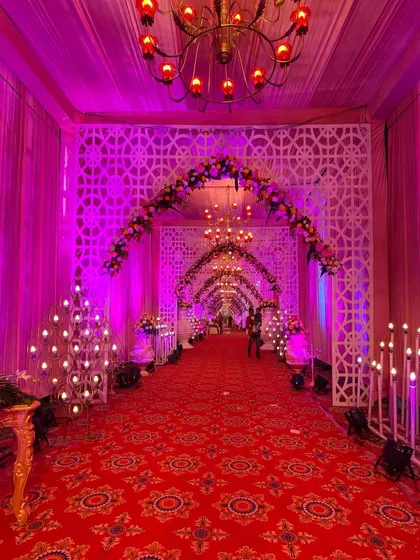 The long view of the red carpet walkway, showing how the repeating arches and chandeliers create a sense of depth and grandeur.