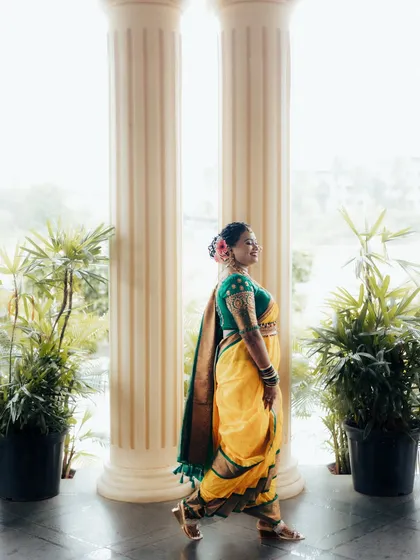 A candid side-profile of the bride as she walks, showcasing the grace of the Nauvari saree and her joyful expression.