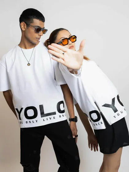 This image showcases the brand's "YOLO" graphic tee with cool, modern accessories. The styling with tinted sunglasses adds to the edgy, youthful vibe of the campaign.