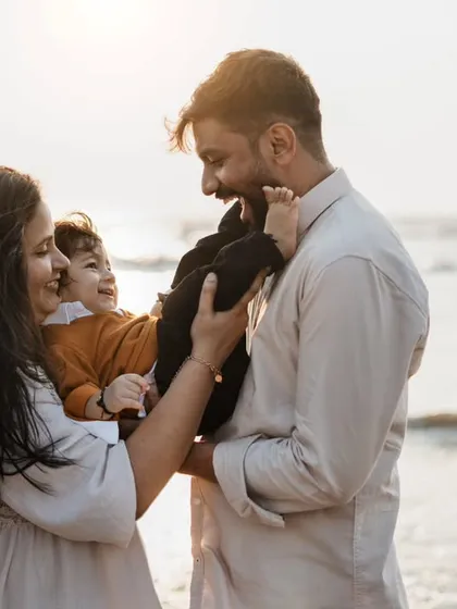 A playful family interaction by the sea. The golden hour light at the beach creates a warm and magical atmosphere for photos.