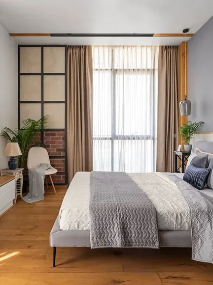 The master bedroom in Apartment 704 is a sanctuary of warmth and modern comfort. Wooden flooring, a cozy TV unit, and a mix of textures create a relaxing environment, with large windows providing ample daylight.