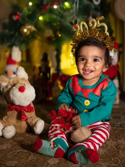 A baby's first Christmas is pure magic. This little elf, with his bright eyes and happy smile, perfectly captures the joy and wonder of the holiday season for a new family.