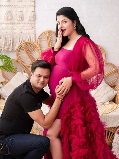 A fun and surprising moment captured on camera. The husband listens to the baby bump while the mother-to-be has a playful, shocked expression. It shows the fun side of their relationship.
