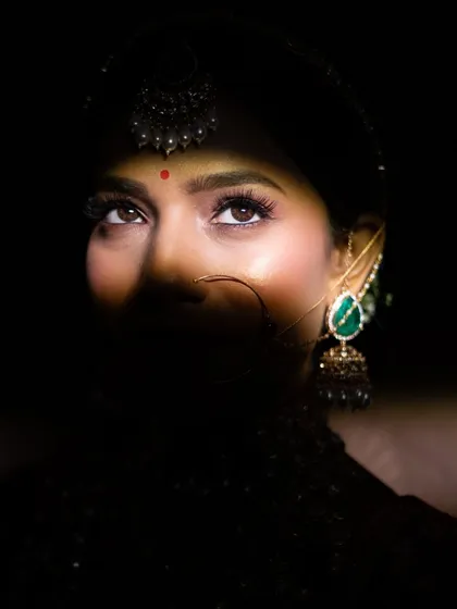 I love playing with light and shadow to create dramatic bridal portraits. This shot highlights the bride's expressive eyes and intricate jewellery, capturing her anticipation and beauty just before the main event.