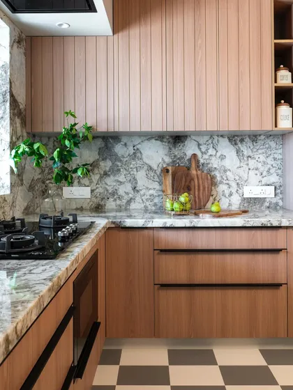 In this kitchen, the warmth of fluted wood cabinetry is paired with a striking marble backsplash. The result is a space that feels both organic and sophisticated, with clean lines and natural patterns creating a balanced, modern aesthetic.