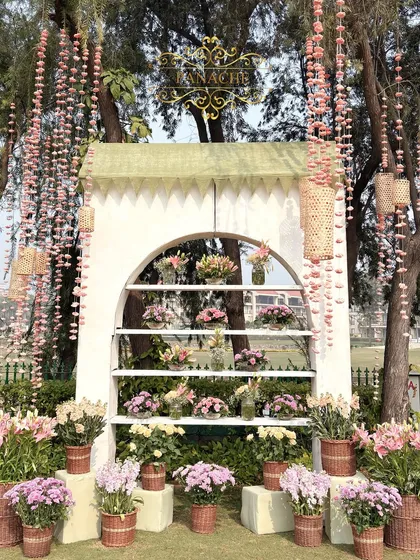 The full view of the bouquet shop photo booth, framed by trees adorned with hanging sola flowers.