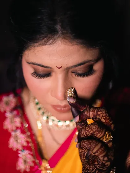 The bride adjusting her nath, a classic pose that captures the essence of Maharashtrian bridal beauty.